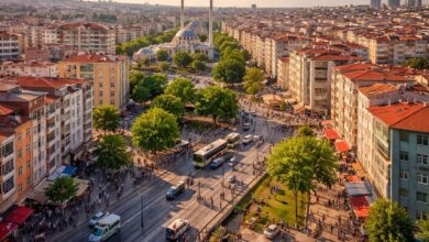 İstanbul Güngören ilçesinde merkezi konumda apartmanlar, ana cadde ve park alanının havadan görünümü